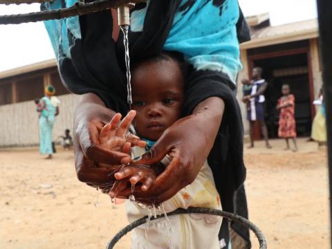 Mother washing he child's hand with clean water
