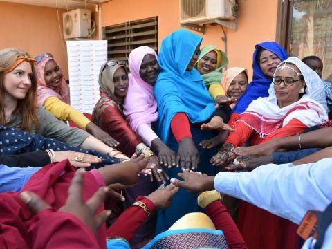 Female staff of World Vision Sudan in the Khartoum office join hands in solidarity