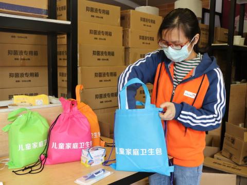 woman in china preparing personal protective gear for World Vision's COVID-19 response