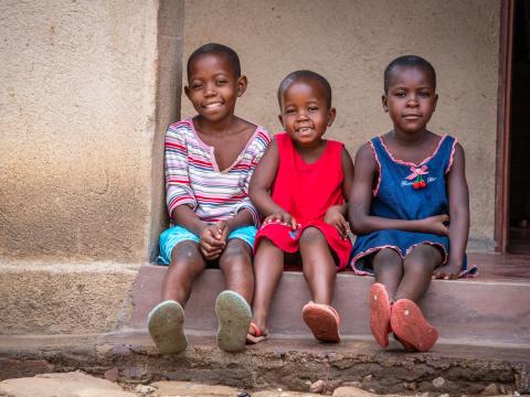 Three Zimbabwean children sitting on a step