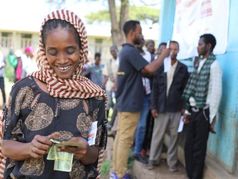 Woman counting cash in Gelana woreda, W. Guji zone, Oromia region