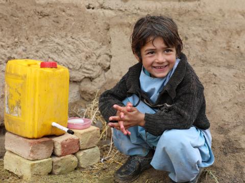 Samiullah is happy to use the water from hand washing station.