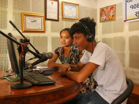 A community radio staff record an episode of a radio programme.