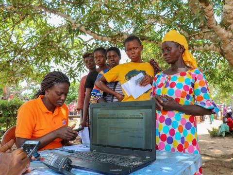 Member of the cash team in DRC verify people’s identities against their registration details and photos, as part of a World Vision cash assistance project. Kate Shaw/World Vision