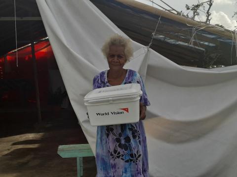 Elcy in front of her church with the hygiene kit