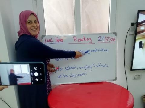Nahed, remedial class teacher, explains a lesson on camera so as to send the video later to her students
