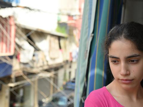 Girl child in Lebanon looking out window following catastrophic explosion