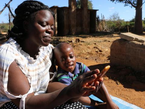 Mother and child use a phone for information and education in Zimbabwe