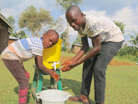 Raphael washing his hands with a younger child in Kenya