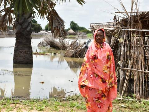 Sudanese woman stands in front of flooding