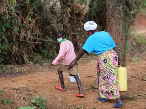 Elizabeth and her son walking back home from fetching water 
