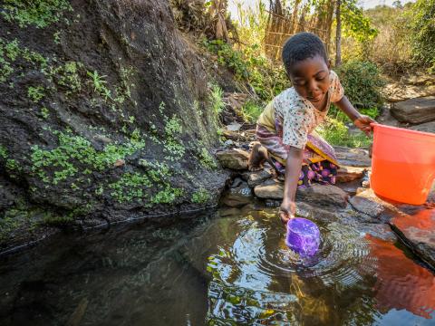 Irene collecting water from a stream in Malawi