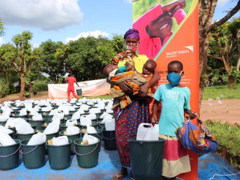 Anguista is holding her five months-old twins after receiving her non-food items kit