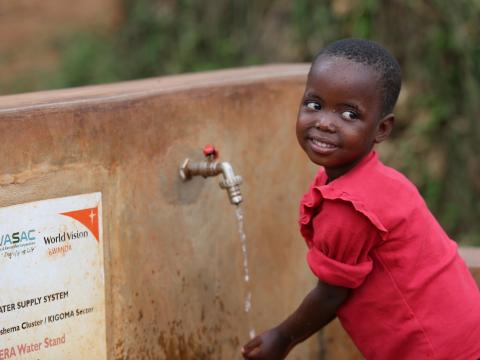 child washing hand at tap