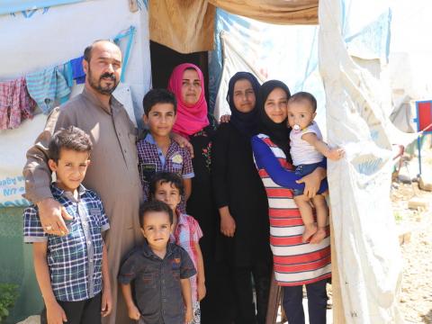 A Syrian family outside their refugee shelter