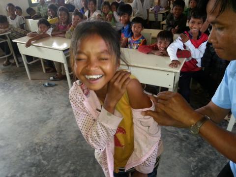 A smiling student gets a measles shot