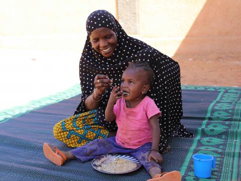 Bassira feeding her daughter Fadjimata