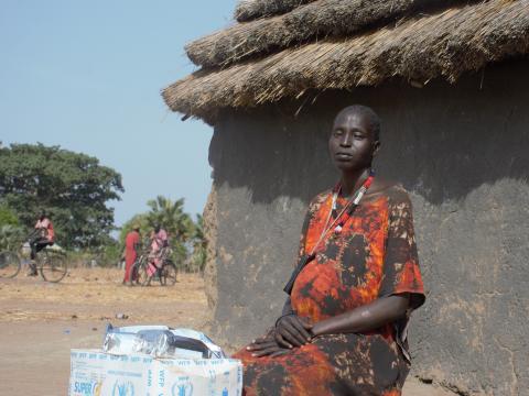 Woman sitting outside a hut in South Sudan