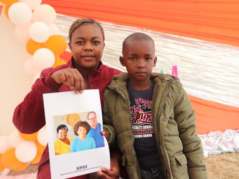 An excited Zandile Ntshangase (left), mother of Mphilwenhle Kunene (right) shows off the photo of their sponsor within USA, they selected at the Chosen event. World Vision Eswatini has helped shift the right to choose a sponsor in Eswatini from sponsors to the sponsored child.