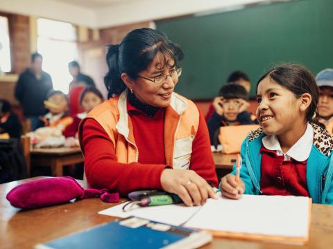 World vision staff sit with sponsored child