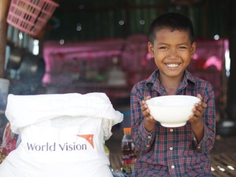Young boy in Cambodia with bowl full or rice