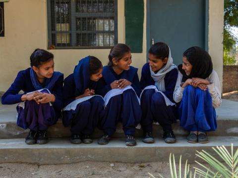 Girls in India sit on the step of the school, grateful for the opportunity to continue their education thanks to safe toilets