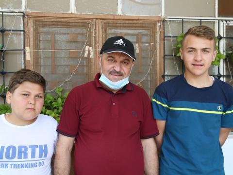 Mohammed, 49, standing with his two sons: Mahmoud and Mohammed