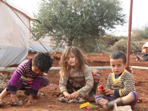 Syrian children play outside World Vision tents