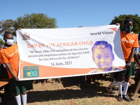 Children posing with the banner