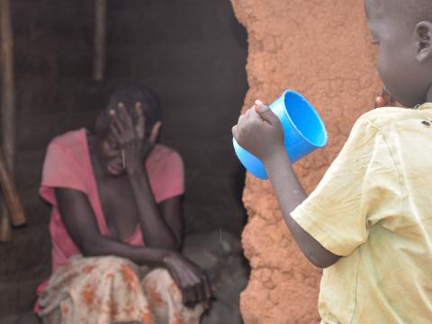 Magdalena looking on as her grandchild eats porridge