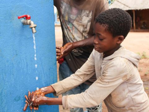 Dercio Chimoio showing running water from the system