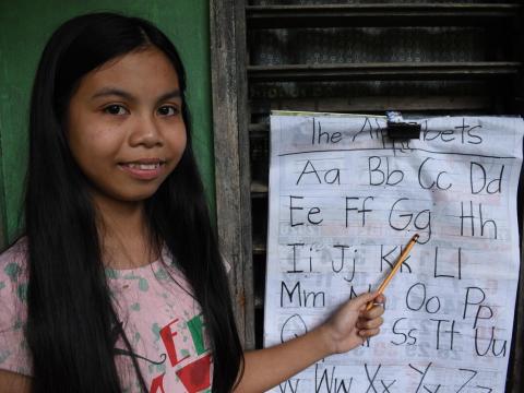 Mary Jane with the chart she uses to teach her sister during COVID-19 lockdowns