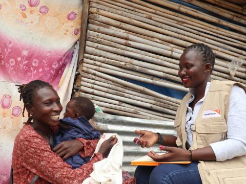 World Vision staff speaks with monther of young child in Africa