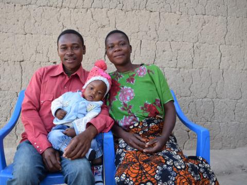 Family that learned the importance of exclusive breastfeeding sits with their happy and health baby in Tanzania