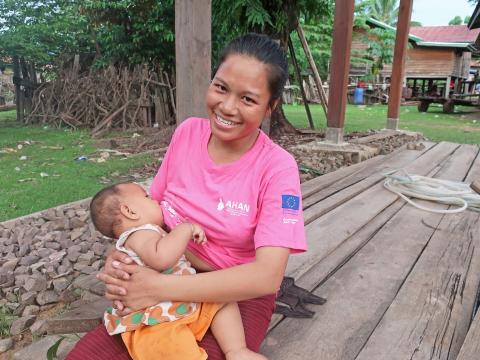 Nok breastfeeds her child in Laos