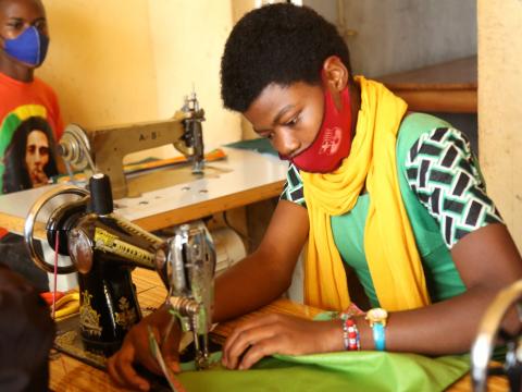 Marie Rose making a cloth with her sawing machine