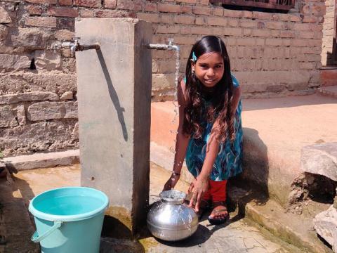 Himanshi collects clean water from the Hub and Spoke network tap.