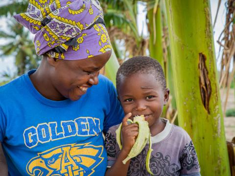 Sponsored child enjoys a banana thanks to kitchen gardens  in Kenya