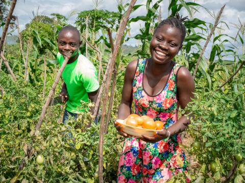 Child in Africa holds produce that her family grew thanks to support from sponsors