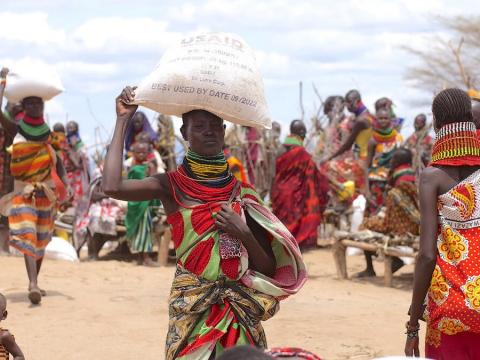 Women walk with sacks of food on their heads