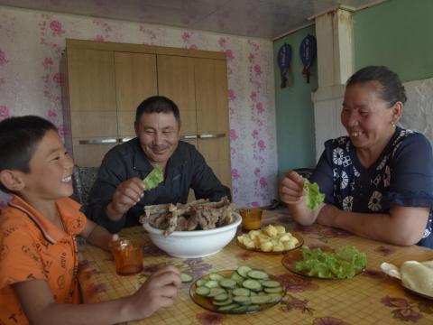 Sponsored child Otgonnyam eats with family.