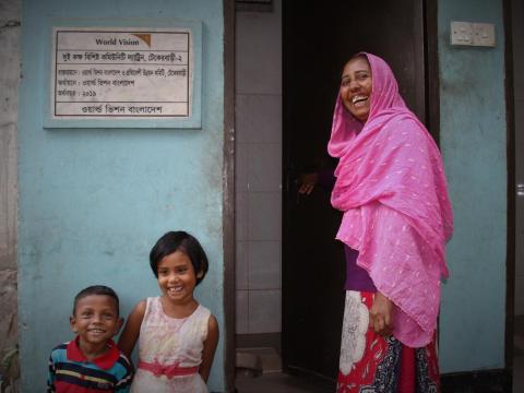 Woman outside a clean toilet built in Bangladesh