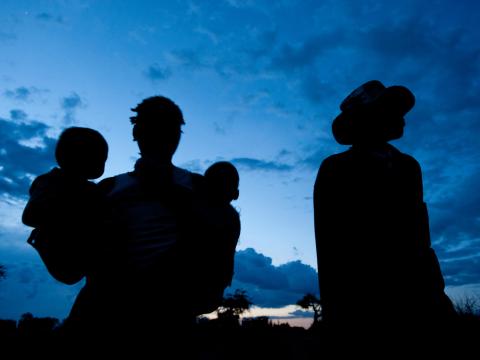 A family silhouetted against a blue sky