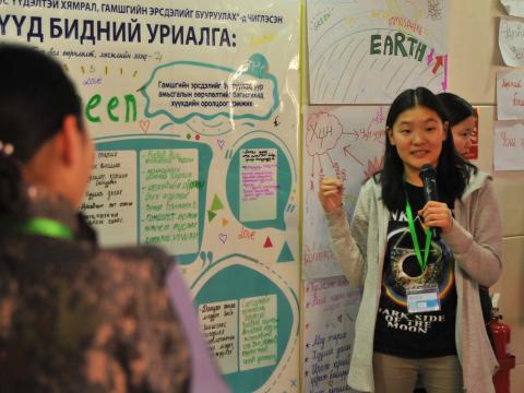 Mongolian youth climate change advocate presenting with a microphone