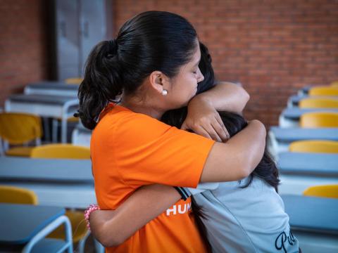 World Vision staff member hugs someone else