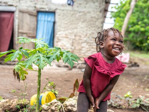 Sponsored child in Haiti grows health and strong and enjoys helping her mother grow papaya and other fruits