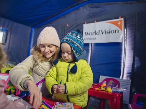 A child her mother in a World Vision space on the Ukraine/Romania border.