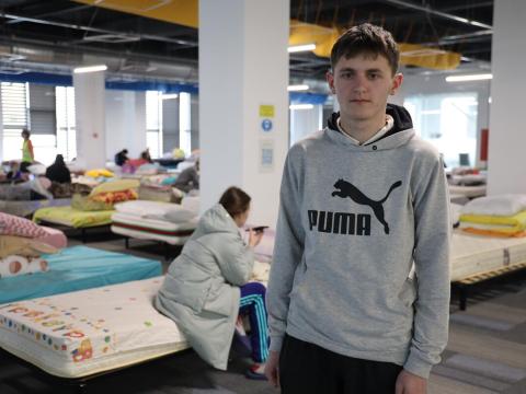 Oleksandr stands in a refugee center