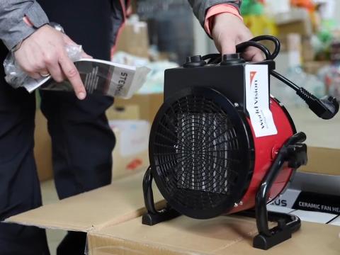 World Vision staff unboxes heaters