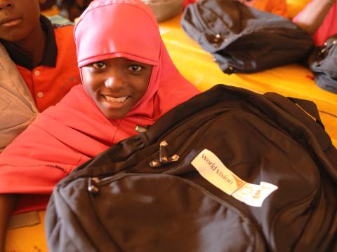 Sakina with the bag and desk she received from World Vision